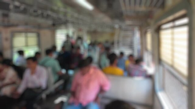 Bokeh view of passengers in moving suburban train, Mumbai, India. Blurred background footage.
