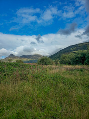 Paysage naturel d’Écosse avec collines verdoyantes sous un ciel bleu nuageux