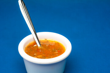 Spicy chili sauce on blue background