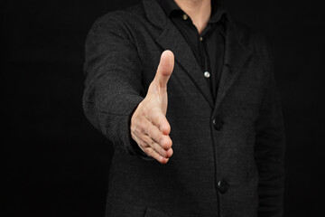 a modern business man giving hand forward his right hand gesture with black background