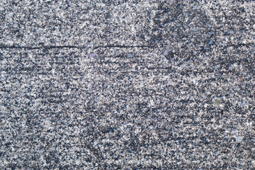 Close-up of rough concrete surface with small stones and grains, natural gray texture background for construction and design use