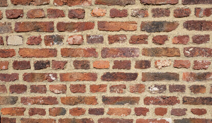 Fototapeta premium Weathered red brick wall with rough surface texture and beige mortar joints, natural rustic construction background pattern