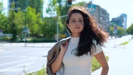 Close up of confident successful young businesswoman walking in street on sunny day. Caucasian beautiful professional female outdoors. Summertime. Urban style. Business lifestyle concept.