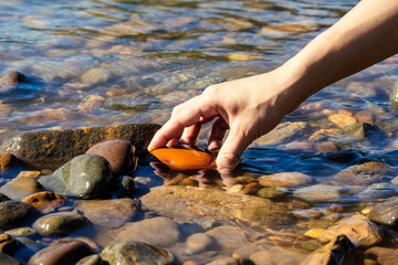 Hand touching the water of a clean and crystal clear river