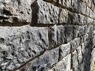 Close-up of sunlit stone brick wall with textured surface