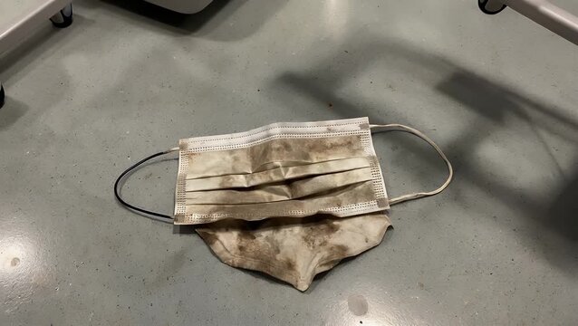 Discarded and Soiled Protective Face Mask Littering an Urban Ground Surface Contributing to Environmental