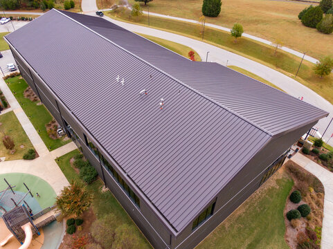 Aerial Drone View of Brown Standing Seam Metal Roof on Modern Commercial Building: Architecture, Roofing, Engineering, Real Estate