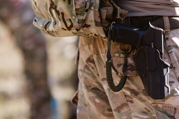 A soldier's pistol in a tactical holster.