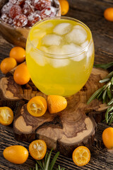 citrus-flavored orange juice and kumquat fruits on a wooden table, delicious and fresh orange juice and fresh kumquat fruits next to a glass