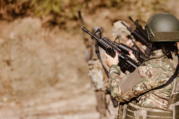 A female soldier holds a rifle during a team exercise.