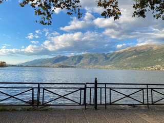 Obraz premium Peaceful lakeside view with mountain range and blue sky on a sunny day