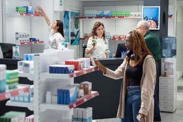 Obraz premium Woman pharmacist supporting retired male client at the checkout counter, reviewing medication instructions, treatment care and assisting in the selection of reliable pharmacy products.