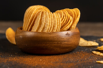 crispy potato chips fried in oil and sprinkled with spices of dried red sweet pepper, a large number of delicious salty sweet pepper-flavored chips with spices
