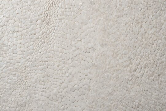 White pebble mosaic texture background. Abstract pattern of small stones with reptilian scale or cobblestone effect. Minimalist and natural surface.