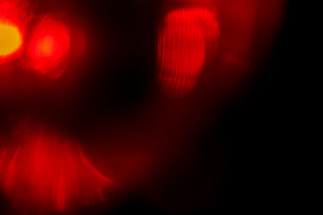 Red color light leaks for design and special effects on dark background. Colorful illuminated light painting.