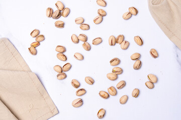 Top view of several pistachio nuts in their shells on a light-colored countertop.