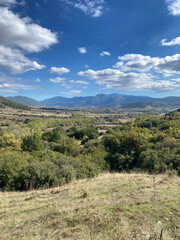 Obraz premium Scenic mountain landscape with rolling hills and cloudy sky