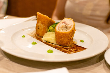 Rollos de pollo frito relleno con puré y brócoli. Cocina gourmet. Fotografía gastronómica con desenfoque.