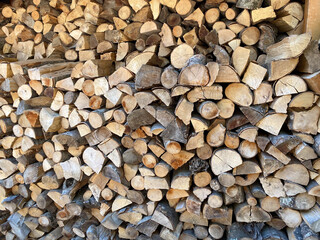 Stacked firewood logs creating rustic textured pattern for cozy winter atmosphere