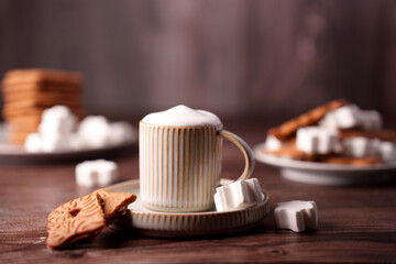 warm cozy scene with ceramic mug of cappuccino, marshmallows, and biscuits on a wooden table, set in a soft ambient light creating a relaxing atmosphere, photography, tones, subtle, composition