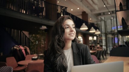Close up, slow motion. Businesswoman working remotely, she is enjoying and looks successful and happy. Woman smiling and waving her hand.