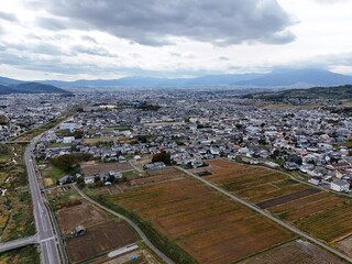 Fototapeta premium A city with a lot of houses and a lot of empty land. The sky is cloudy and the sun is not visible