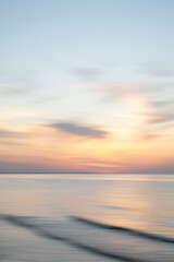 Artistic Blurred Background of Sea, Sky and clouds during a soft colours sunset. Copy space.