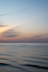 Obraz premium Artistic Blurred Background of Sea, Sky and clouds during a soft colours sunset. Copy space.