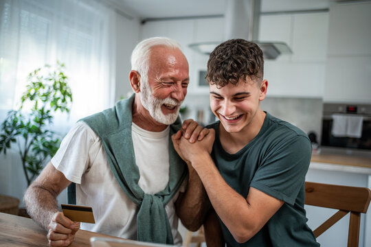 Grandfather grandson enjoying online shopping using credit card