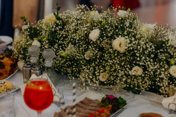 Elegant floral decorations on dining tables prepared for celebration, beautiful flower arrangements creating festive and romantic atmosphere