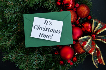 Greeting card with IT'S CHRISTMAS TIME text on handmade Christmas wreath. Festive mood new year...