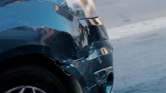 Close up of a scratched and dented car bumper on the street