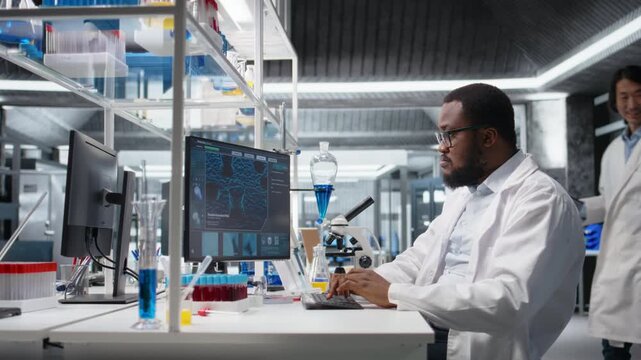 Lab specialist doing genetics study using clinical equipment, removing eyeglasses, checking analysis results on computer. Man using scientific gear at workbench, doing complex experiments, camera A