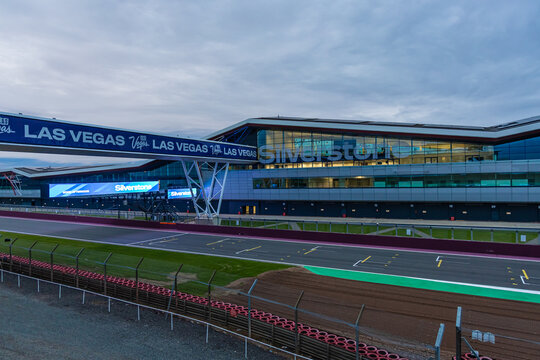 The Silverstone pit building lit up at twilight, ideal for motorsport, travel, and architecture themes.
