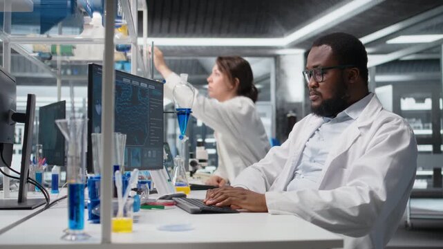 Scientist in laboratory interprets clinical blood values on computer monitor during study. Research facility worker doing sanguine fluid analysis, looking at healthcare insights report on PC, camera A