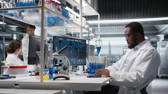 Scientist typing on keyboard, using computer program for DNA data analysis in laboratory driving treatment discovery. Expert using bioinformatics software on PC in sterile lab, camera A