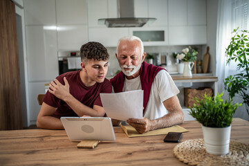 Grandfather grandson learning financial documents together at home