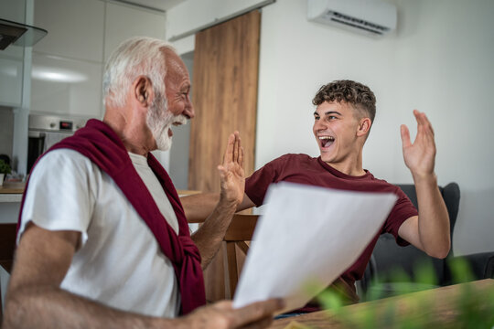Grandfather and grandson celebrating success with high five