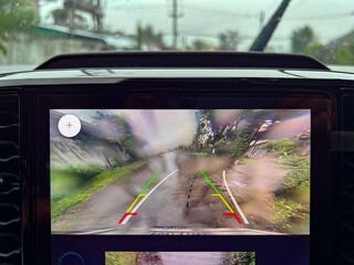 Rain drops on car rearview camera lens causing blurred vision and safety issue