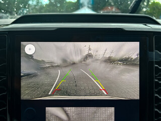 Rain drops on car rearview camera lens causing blurred vision and safety issue