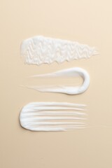 Samples of different cosmetic products on beige background, flat lay