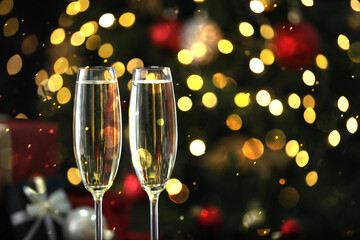 Sparkling wine in glasses, bokeh lights. New Year greeting card