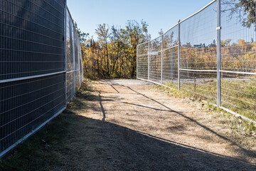 Fenced path in Hawrelak Park during Rehabilitation project in fall season