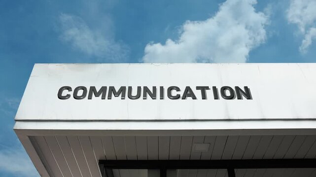 Communication word sign clearly displayed on the modern, institutional or commercial building facade beneath a clear blue sky, signifying a core focus on media, information, or telecommunications
