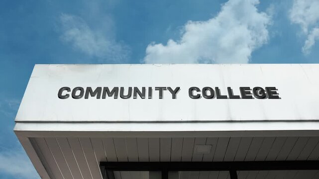 Community College word sign prominently displayed on the accessible educational facade beneath a clear blue sky, signifying a non-residential, public higher education facility for vocational
