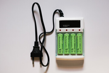 close up row of NiMH AA rechargeable batteries on charger box isolated on white background