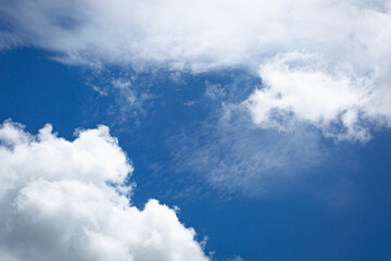 Obraz premium Blue sky with soft white clouds in close-up view, creating a calm and refreshing natural background