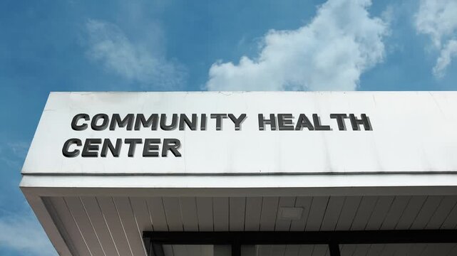 Community Health Center word sign clearly displayed on the medical facility facade beneath a clear blue sky, signifying an accessible non-profit clinic offering primary care, preventive services
