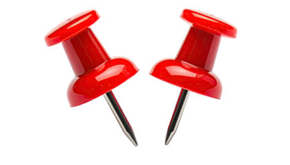 Two bright red pushpins isolated on a black background, closeup