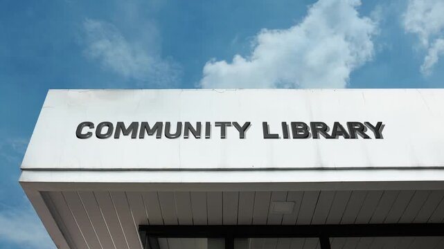 Community Library word sign clearly displayed on the accessible civic facade beneath a clear blue sky, signifying a local public resource facility for books, literacy, and neighborhood learning